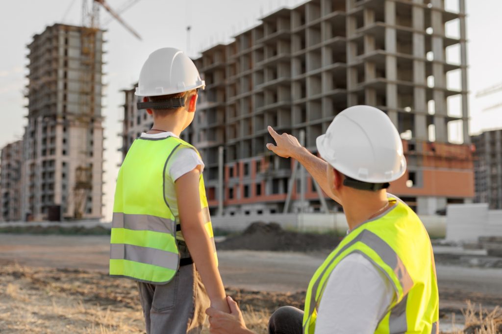 Dad shows his son their new apartment in a building under construction.